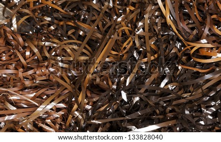 Close-up view of entangled magnetic tapes in various hues of brown, taken off (many) audio cassettes.
