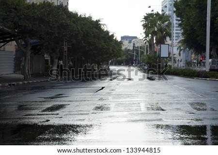 Early winter morning in Tel-Aviv, the wet street is empty from vehicles and people.
