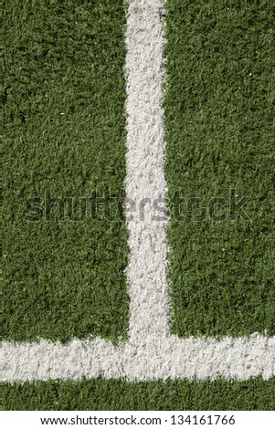 Close up of artificial lawn painted on with white stripes. Part of a sports field.