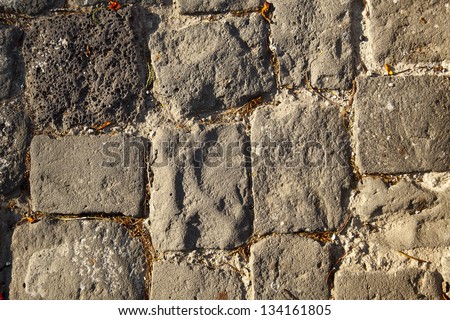 Rough floor tiles made of rocks lit by afternoon sun. Good as background.