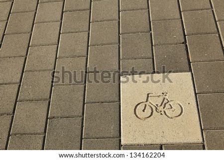 Diagram of a bicycle engraved on the pavement, indicating it\'s a bicycle path.