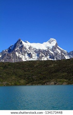 A view on a lake and mountain covered with snow behind it. Shot in Patagonia, South America.