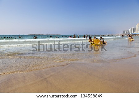 TEL AVIV - AUGUST 18: Several people cooling off at the Tel Aviv beach, with hotel strip in the background. On August 18 2012 in Tel Aviv, Israel.