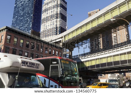 NEW YORK - NOVEMBER 6th: Wide angle horizontal view of two buses amongst the traffic at 9th avenue, with the Port Authority bus terminal in the background on November 6 2012 in New York, New York.