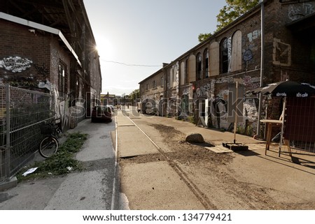 BERLIN - JUN 9: A view at the Raw tempel area main road, with graffiti covered buildings on both sides, located in Friedrichshain on June 9 2012 in Berlin, Germany.