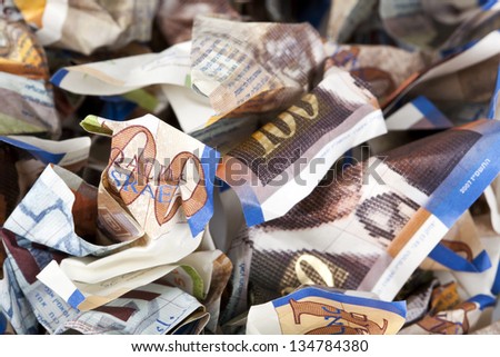 A macro shot of crumples 100 Israeli New Shekels money notes.