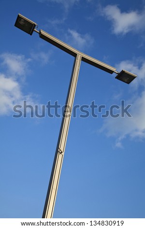 A high voltage street light shot from a low angle on the background of lovely blue sky with a few clouds. This image was shot in Tel Aviv, Israel.