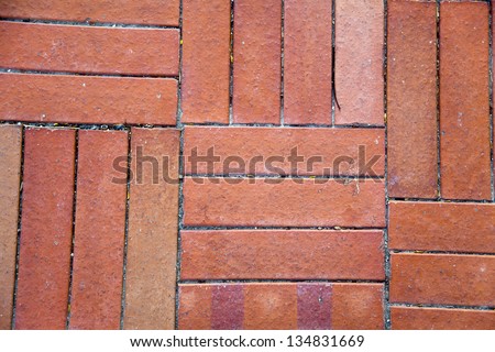 Red brick shaped floor tiles lit by diffused afternoon sun. Good as background.
