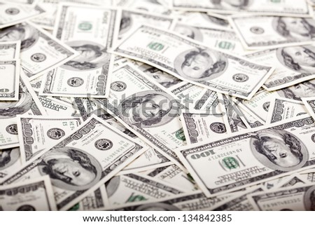 A high angle view of a very large amount of 100 US$ money notes in a bulky mess. Shallow depth of field.