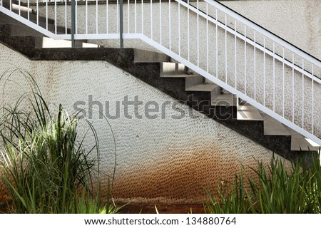 Side view of a flight of stairs located in a patio, leading from the balcony to the ground level.
