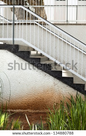 Side view of a flight of stairs located in a patio, leading from the balcony to the ground level.