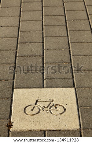Diagram of a bicycle engraved on the pavement, indicating it\'s a bicycle path.