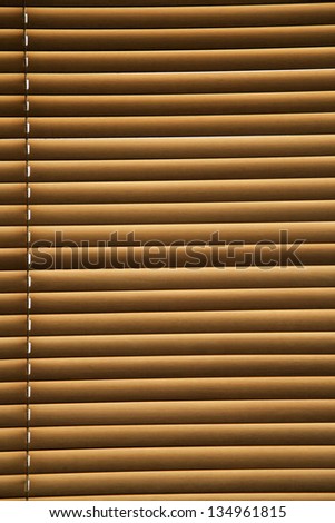 Closed Venetian blinds, back lit by the sun.