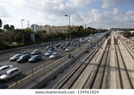 TEL AVIV - JUN 28: The empty railroad next to the Ayalon highway, at the peak of the afternoon rush hour when the road is jammed with cars at the end of a work day on June 28 2012 in Tel Aviv, Israel.