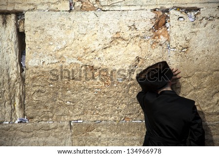 JERUSALEM - MAY 20: An orthodox Jewish adult pressed in prayer against the wailing wall in the old city of Jerusalem on May 20 2010 in Jerusalem, Israel.