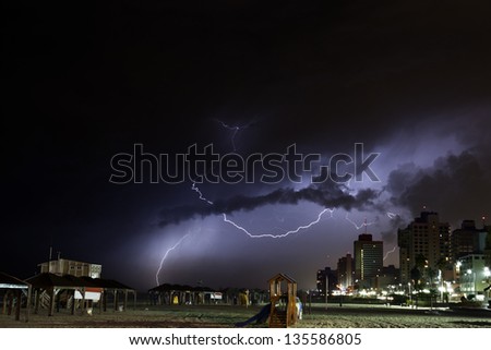 Ominous storm clouds cover the sky over Tel-Aviv Beach, shooting lightnings on a winter night. (slight grain, best used at small size)