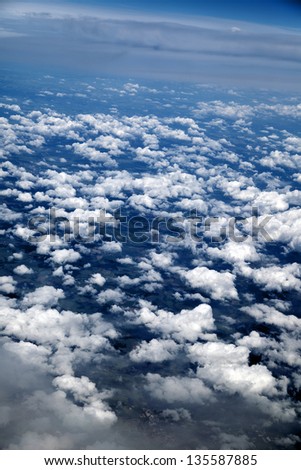Aerial view of clouds over green land features.