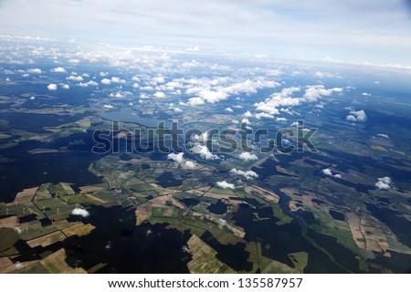 Aerial view of clouds over green land features.