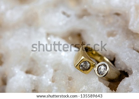 A gold/white gold ring inlaid with diamonds resting on a rock made of clusters of salt crystals. Shot on the beach of the infamously salty Dead Sea in Israel.