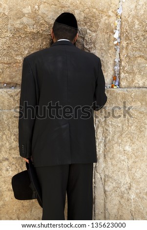 JERUSALEM - MAY 21: An orthodox Jewish young adult pressed in prayer against the wailing wall on May 21 2010 in Jerusalem, Israel.