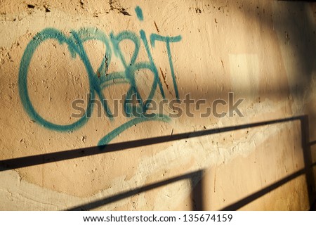 A graffiti tag \'orbit\' on an urban wall. Shot in the early morning.