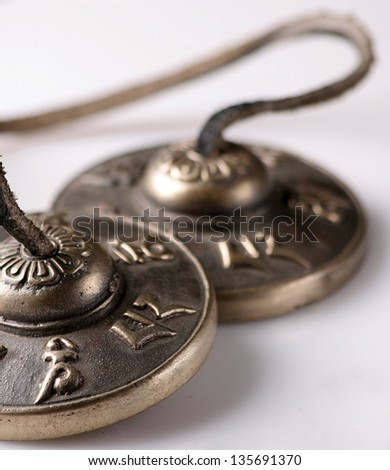 Buddhist Brass ceremonial bells with a leather strap on white background.