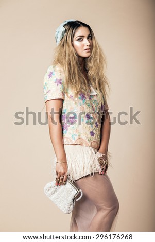 Studio shot of a stylish looking attractive young woman, looking at the camera with a nonchalant gaze.