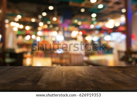 Empty dark wooden table in front of abstract blurred background