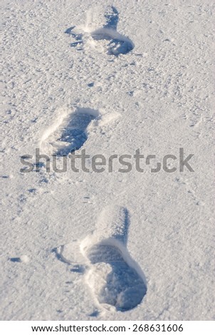 Human footprints in the snow in winter.