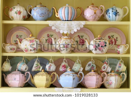 Vintage yellow kitchen dresser display of teacups tea cup teapots floral and pastel - high tea party