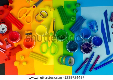 School accessories are laid out in the form of a rainbow. Black background.Happy back to school student. Art and crafts for kids. Child learning rainbow colors, alphabet letters and numbers.