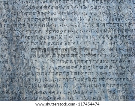 Ancient sanskrit text etched into a stone tablet.
