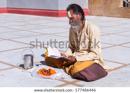 Gangotri, Uttarakhand - CIRCA May 2013 - A Hindu priest sits in the temple courtyard to read Vedic scriptures in Gangotri circa May 2013.