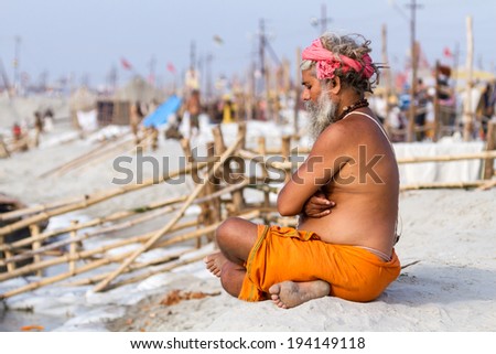 ALLAHABAD, INDIA - FEB 14 - A Hindu pilgrim sits in meditation on the banks of the holy river during the festival of Kumbha Mela on February 14th 2013 at Allahabad, India.