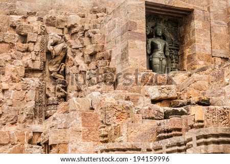 An ancient deity in a small alcove next to a crumbling wall at the Sun Temple of Konark, India.