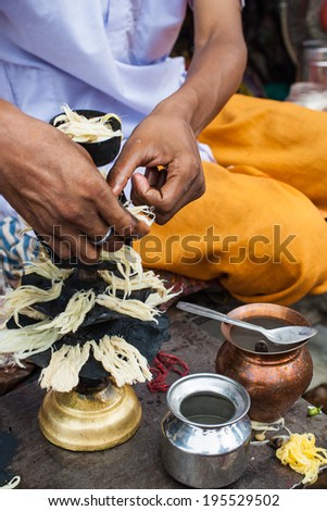 A Hindu priest preparing oil lamps to offer in the Ganga Aratik at Haridwar in India.