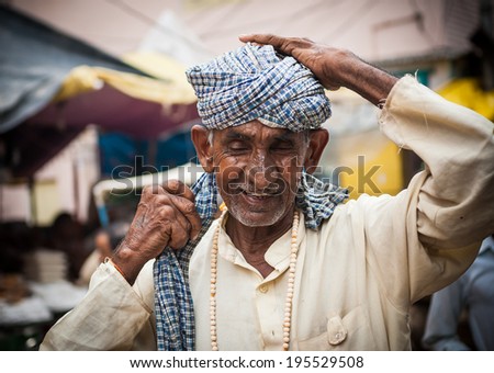 HARIDWAR, INDIA - AUG 10 - A Hindu Pilgrims wraps his head with a checkered cloth as a turban on August 10th 2010 at Haridwar, India.