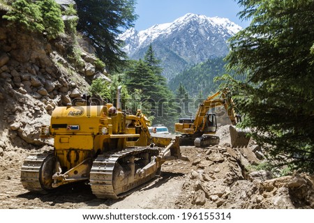 Gangotri, Uttarakhand - CIRCA May 2013 - Bulldozers clear fallen earth after a landslide on a road in Gangotri circa May 2013.