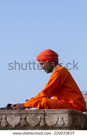 VARANASI, INDIA - FEB 18 - A Hindu holy man studying a Sanskrit text on February 18th 2013