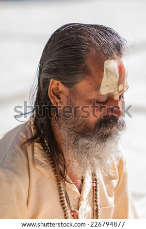GANGOTRI, INDIA - MAY 23rd - A Hindu priest sits in the temple courtyard to read Vedic scriptures in Gangotri on 23rd May 2013.