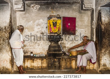 MELKOTE, INDIA - DEC 8th - Two Hindu priests tend to one of the shrines at a temple in Melkote, India on December 8th 2011.