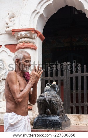 PURI, INDIA  OCTOBER 9th 2010  An old man prays outside a temple of Shiva in East India.