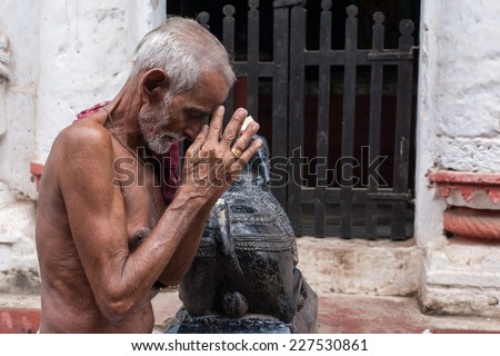 PURI, INDIA OCTOBER 9th 2010 An old man prays outside a temple of Shiva in East India.
