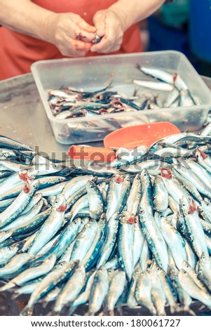 man cleaning fresh caught saltwater fishes and preparing them on a tablet