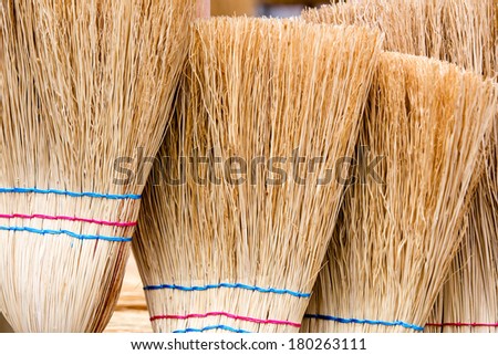 a group of straw brooms