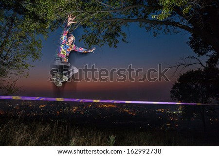 Man walking on a tightrope at sunset slack-line