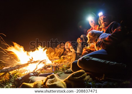 Bonfire in a camp in the mountains and the light of flashlights