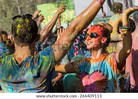a crowd of people dancing on a colorful festival of colors