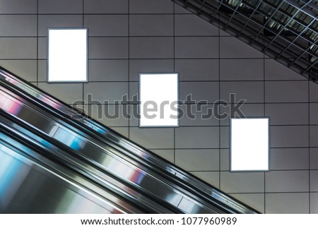 Blank poster mockup in metro station. Three big vertical / portrait orientation blank poster with metro escalator background.