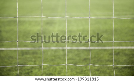 Football - Goal net - A close-up of a soccer net on green grass background